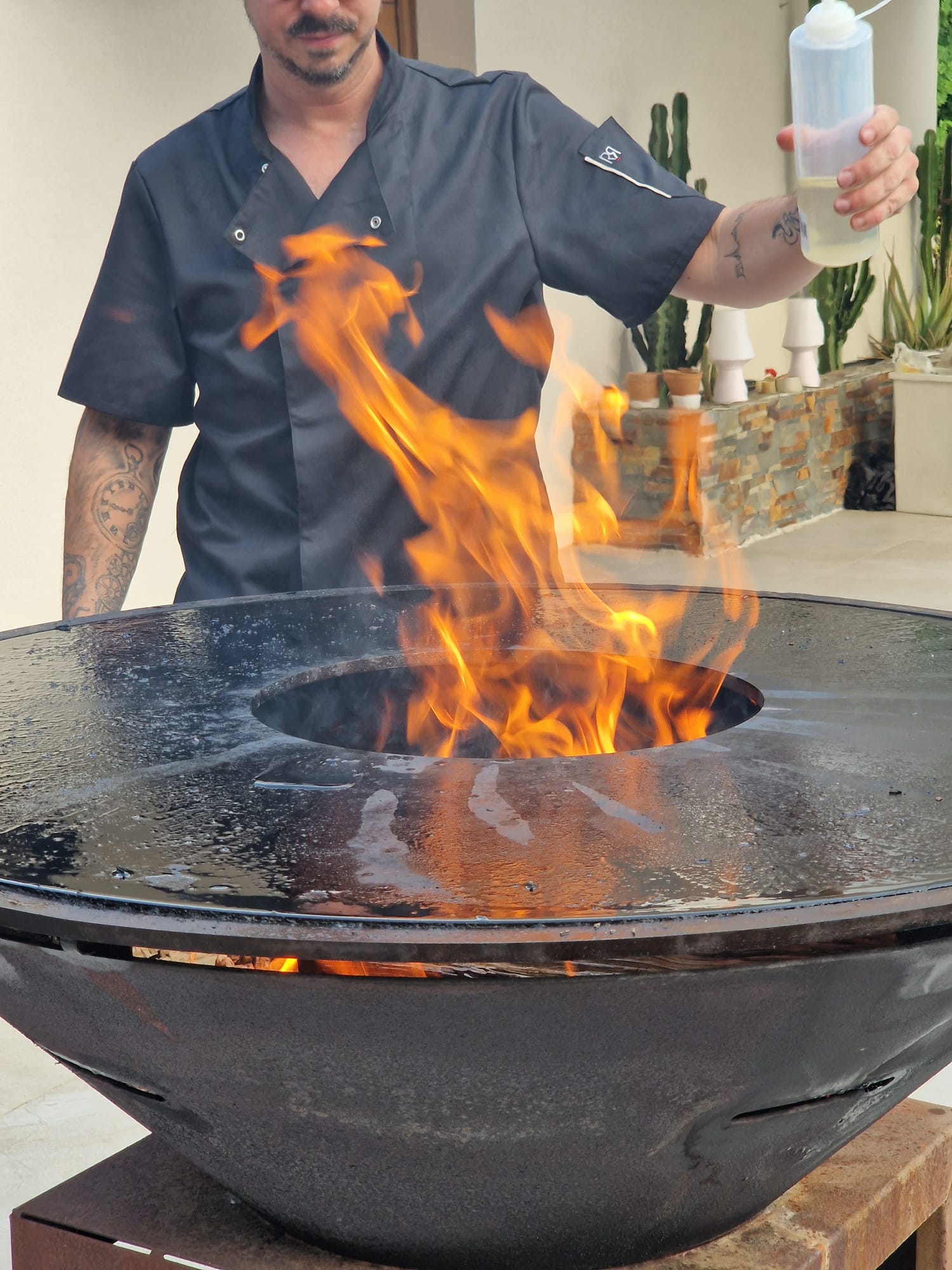 Chef Wild Kitchen huilant la plancha au-dessus du feu
